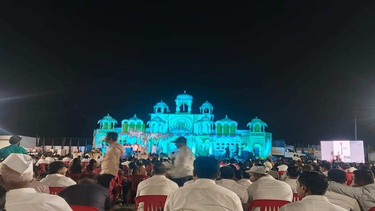 Trupti Films : Large crowd attending a night cultural event in Shirur Maharashtra with illuminated stage and colorful lighting